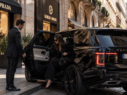 Private Chauffeur in Milan: Young woman stepping out of a car with a private chauffeur