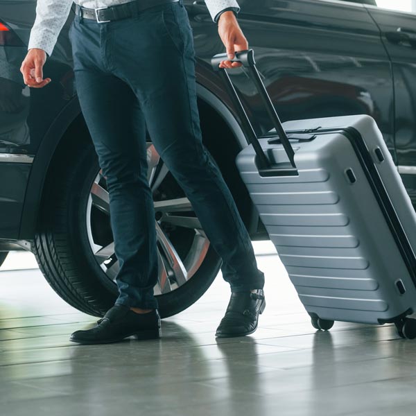 Hire Car with Driver Milan: Vip Limousine and Identità Golose 2024 Hire Car with Driver Milan: Partial view man formal clothes is with luggage near car